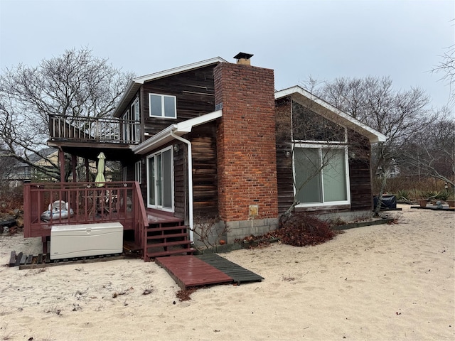 view of side of property featuring a balcony and a deck