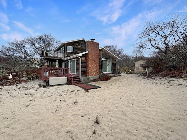 65 Lake Dr, Southold, NY 11971 - view of property exterior featuring a chimney, a wooden deck, and a balcony