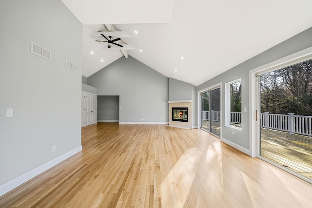 unfurnished living room featuring ceiling fan, beamed ceiling, light hardwood / wood-style floors, and high vaulted ceiling