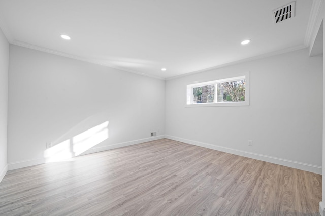 spare room featuring light hardwood / wood-style flooring and ornamental molding