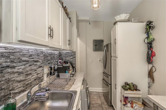 1383 Plimpton Ave Unit 5B, Bronx, NY 10452 - kitchen featuring electric panel, freestanding refrigerator, white cabinets, decorative backsplash, and tile patterned flooring