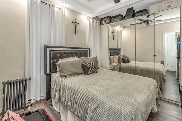 bedroom featuring wood-type flooring, a closet, and radiator