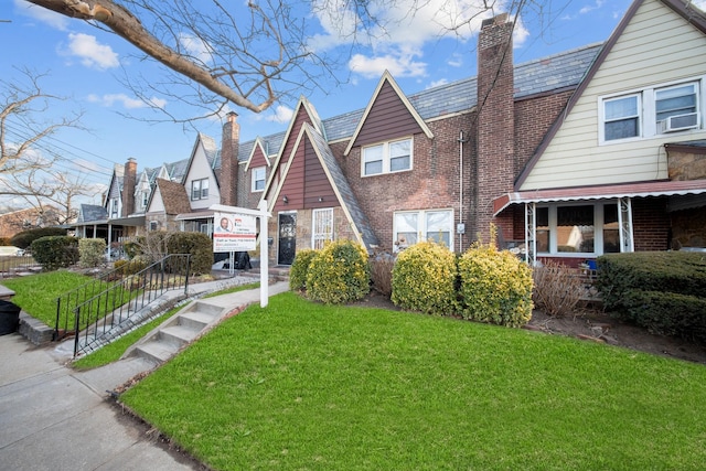 english style home with a front lawn