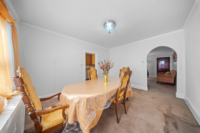 dining area with ornamental molding and light colored carpet