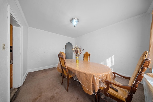 carpeted dining space with crown molding