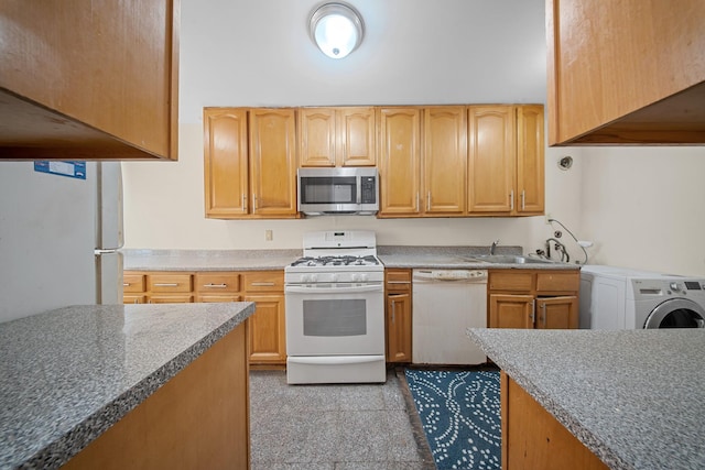 kitchen featuring white appliances, washer / dryer, and sink