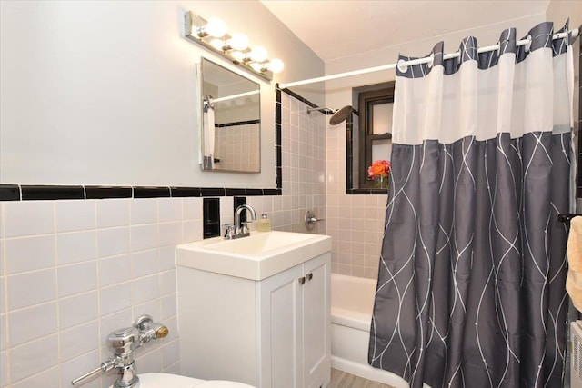 full bathroom with shower / bath combo, toilet, tile walls, and vanity