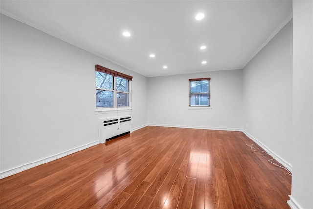 unfurnished living room featuring radiator, crown molding, and wood-type flooring