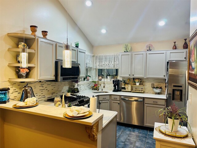 kitchen featuring sink, hanging light fixtures, lofted ceiling, decorative backsplash, and appliances with stainless steel finishes