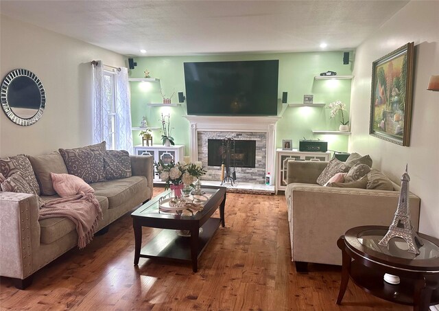 living room featuring hardwood / wood-style floors and a stone fireplace