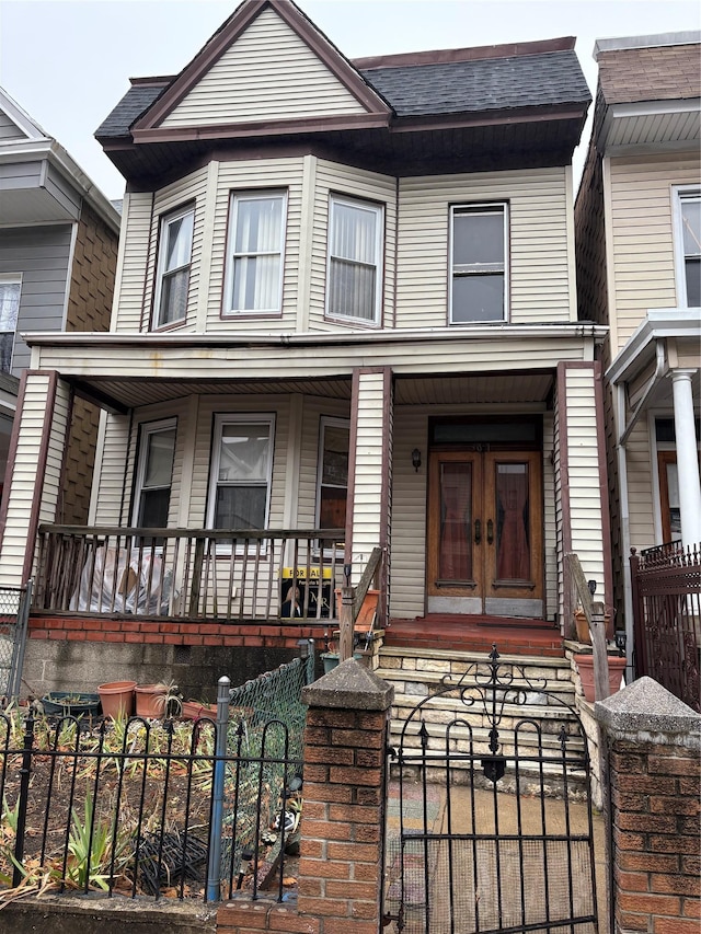 view of property with a porch and french doors