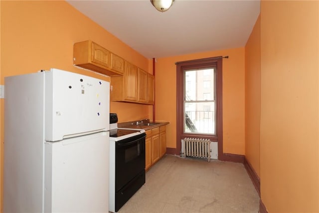 kitchen with radiator heating unit, sink, white appliances, light carpet, and light brown cabinetry