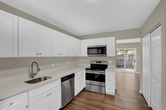 kitchen with dark hardwood / wood-style flooring, sink, white cabinetry, and stainless steel appliances