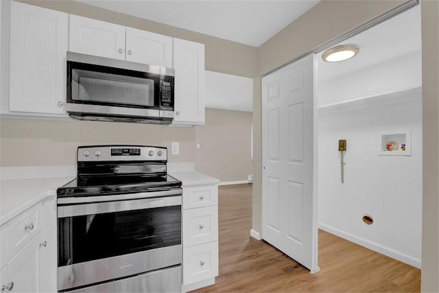 kitchen featuring appliances with stainless steel finishes, light hardwood / wood-style flooring, and white cabinetry