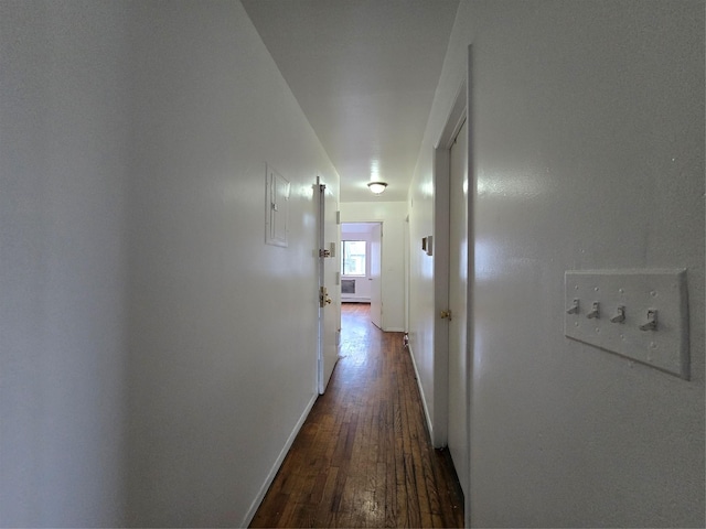 hall featuring baseboards and dark wood-style flooring