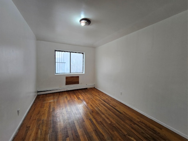 empty room featuring baseboards, dark wood-style flooring, and a baseboard radiator
