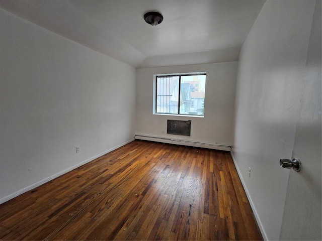 unfurnished room featuring dark wood-type flooring, baseboards, and a baseboard heating unit