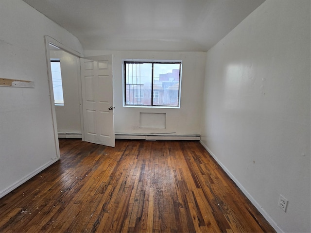 spare room with a baseboard radiator, hardwood / wood-style flooring, and baseboards