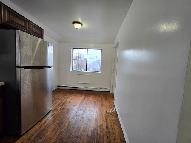 kitchen with dark brown cabinetry, freestanding refrigerator, dark wood-style floors, baseboards, and a baseboard heating unit