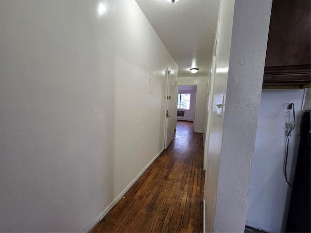 hallway with dark wood-type flooring and baseboards