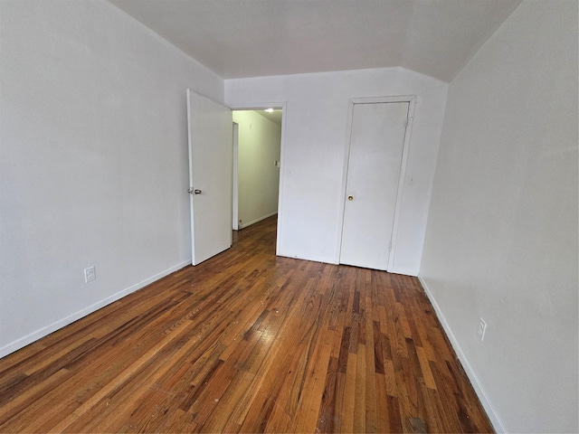 unfurnished bedroom with hardwood / wood-style flooring and baseboards