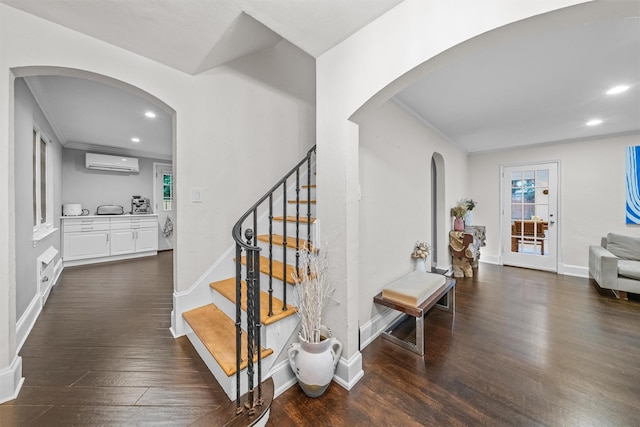 stairs with hardwood / wood-style floors, crown molding, and a wall mounted AC