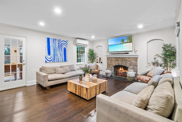 living room with a fireplace, ornamental molding, dark wood-type flooring, and a wall mounted AC