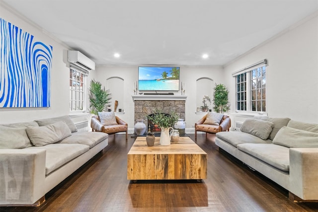 living room featuring dark hardwood / wood-style floors, crown molding, a fireplace, and a wall mounted AC