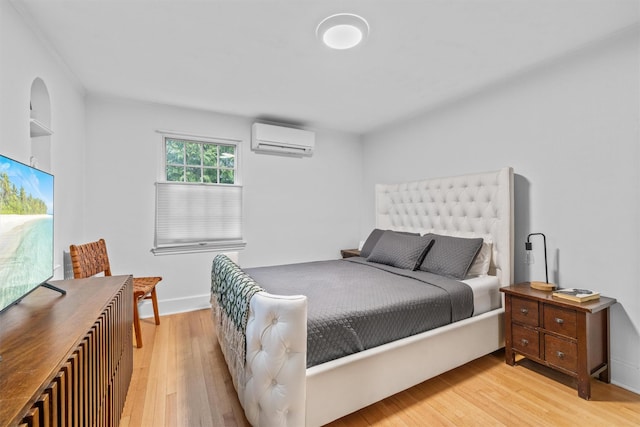 bedroom featuring light wood-type flooring and a wall mounted AC