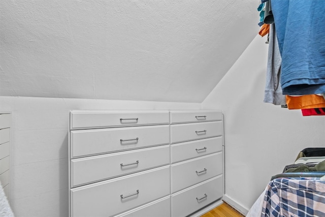 walk in closet featuring light wood-type flooring and lofted ceiling