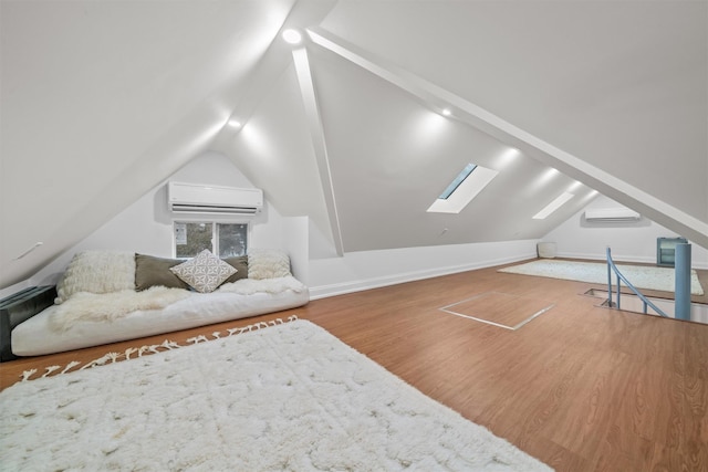 bonus room featuring a wall unit AC, hardwood / wood-style floors, and vaulted ceiling with skylight