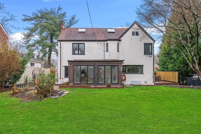 rear view of property featuring a sunroom and a lawn