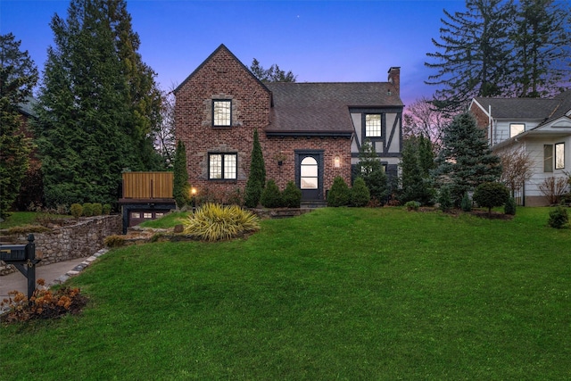 tudor-style house featuring a yard