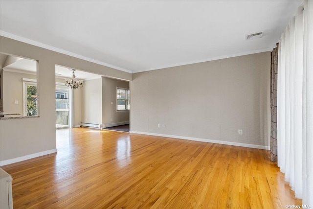 empty room featuring an inviting chandelier, ornamental molding, and light hardwood / wood-style floors