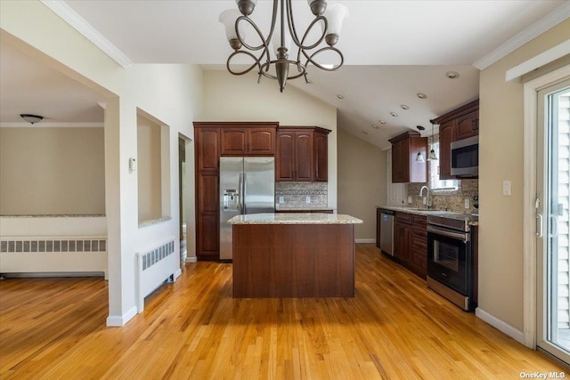 kitchen with radiator, backsplash, stainless steel appliances, and a kitchen island