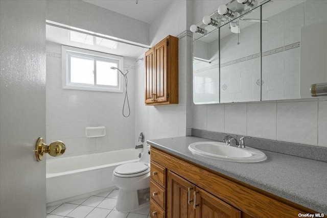 full bathroom with toilet, tile walls, tile patterned floors, tub / shower combination, and vanity