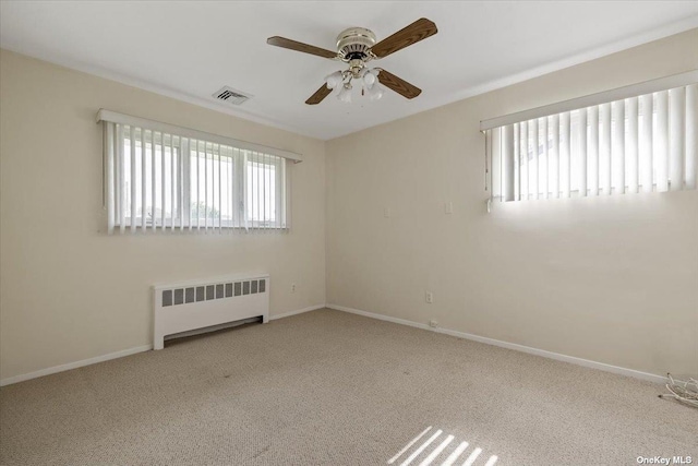 unfurnished room with light carpet, radiator, and a healthy amount of sunlight