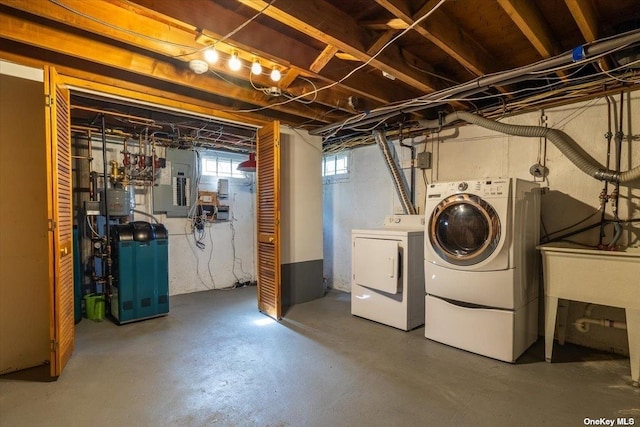 basement featuring sink, electric panel, and independent washer and dryer