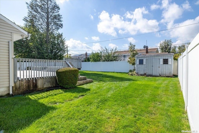 view of yard featuring a wooden deck and a shed