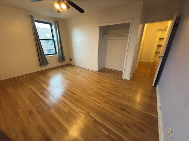 unfurnished bedroom featuring ceiling fan, a closet, and hardwood / wood-style flooring