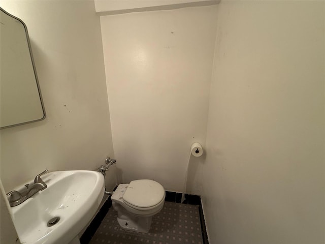 bathroom with tile patterned flooring, toilet, and sink