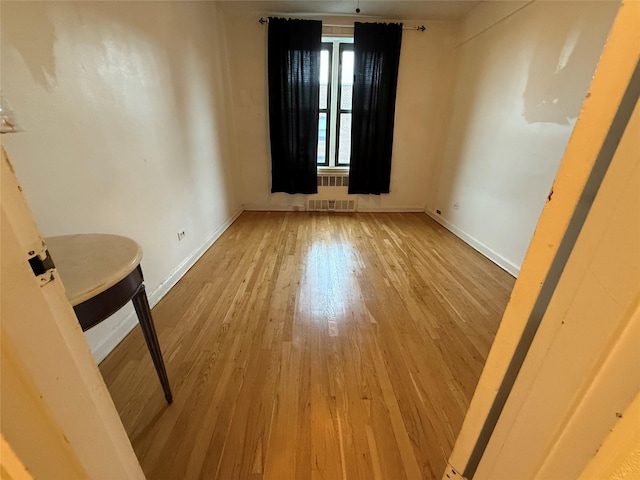 spare room featuring light hardwood / wood-style flooring and radiator