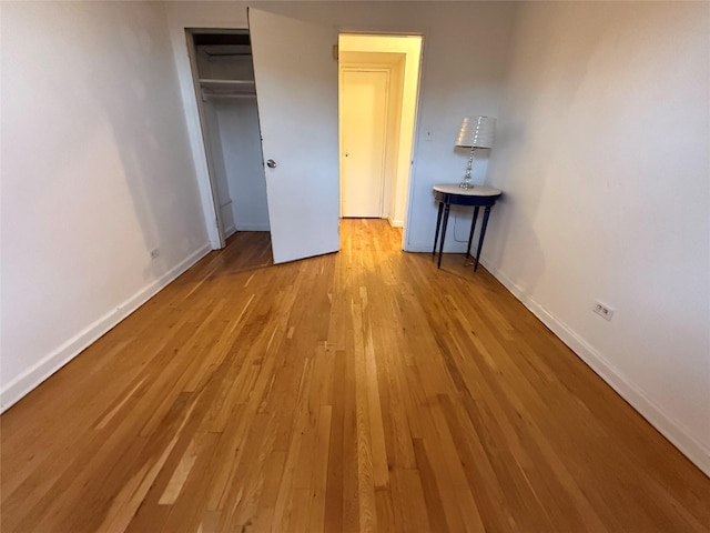 unfurnished bedroom with a closet and light hardwood / wood-style floors