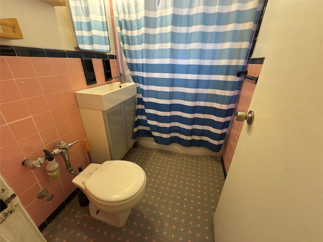 bathroom featuring a shower with shower curtain, toilet, and tile walls