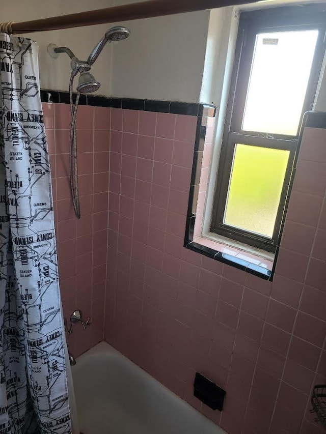 bathroom featuring plenty of natural light and shower / tub combo with curtain