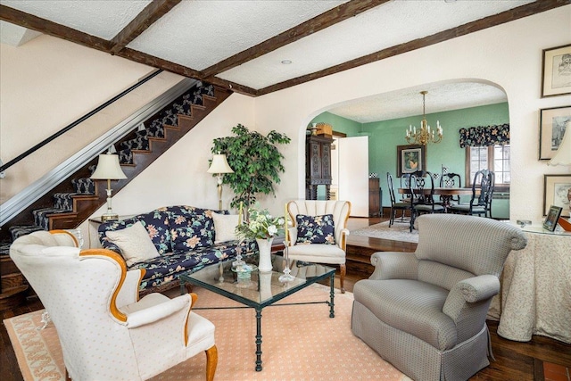 living room featuring beam ceiling, a textured ceiling, hardwood / wood-style flooring, and a notable chandelier