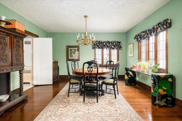 dining space featuring a textured ceiling, dark hardwood / wood-style floors, and a notable chandelier