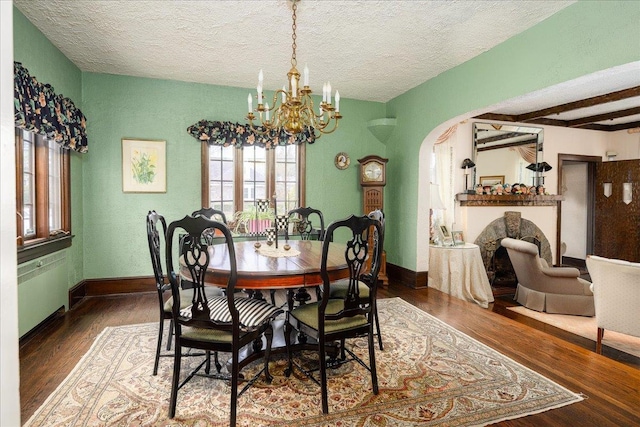 dining area with a textured ceiling, beamed ceiling, dark hardwood / wood-style floors, and an inviting chandelier