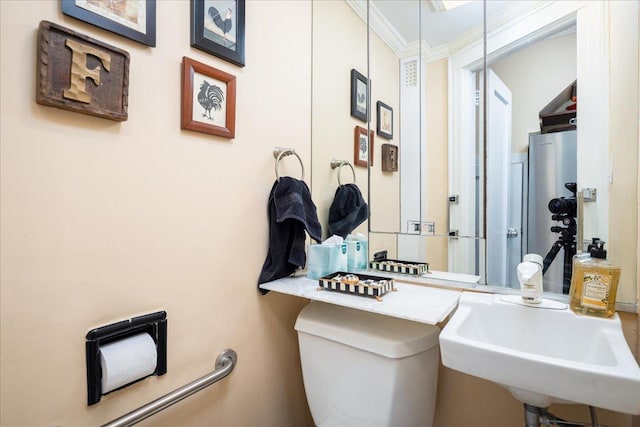 bathroom with toilet, ornamental molding, and sink