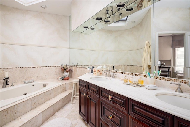 bathroom featuring tile patterned floors, tiled bath, and vanity